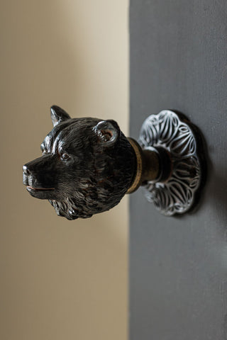 The Bear Door Knob on a black door.