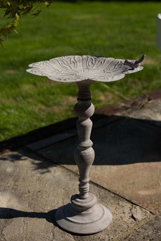 The Beautiful Bird Bath On Stand displayed on a patio in the sunshine.
