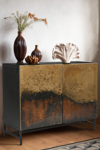 The Beautiful Burnished Metal Sideboard styled with various vases and ornaments on.