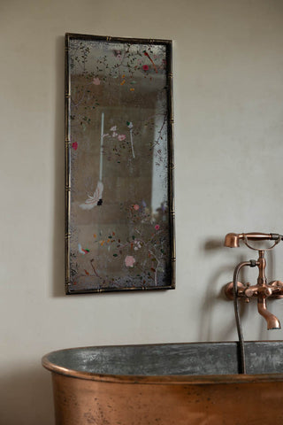 The Beautiful Pink Chinoiserie Decorative Mirror styled on the wall above a bath.