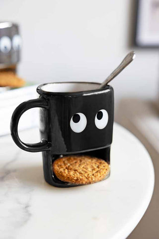 A very funny mug. The black mug has a face with googley eyes and a slot to keep a biscuit in; perfect for tea and biscuits.