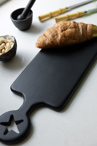 The Black Kitchen Disco Slim Serving Board styled with a croissant and kitchen accessories.