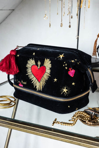 The Black Milagro Heart Velvet Wash Bag styled on a glass table with various jewellery.