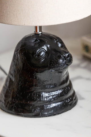 Close-up of the seal detail on the Black Seal Table Lamp With Linen Shade.