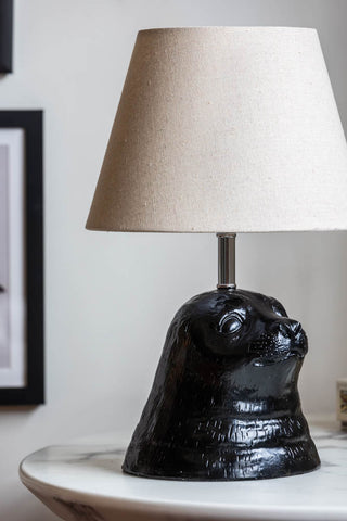 Close-up of the Black Seal Table Lamp With Linen Shade on a white table.