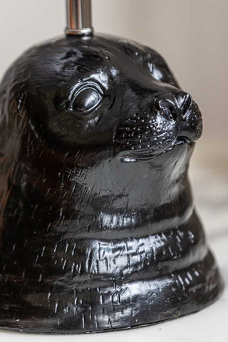 Close-up of the seal's face on the Black Seal Table Lamp With Linen Shade.