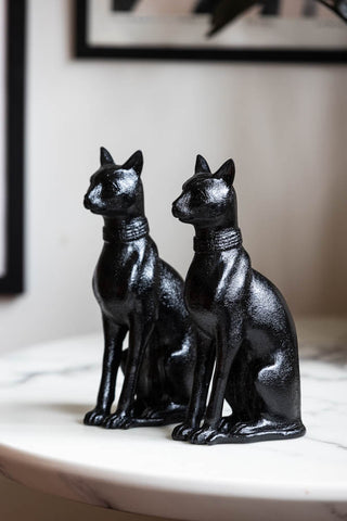 The Black Sitting Cat Bookends sitting on a table facing the same direction.