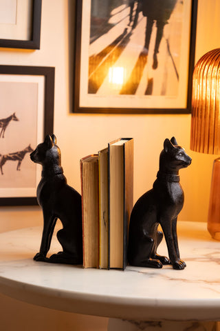 Pair of Black Sitting Cat Bookends with books and orange lamp on