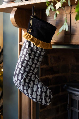 The Luxury Christmas Tree Stocking shown hanging from a wooden mantlepiece.