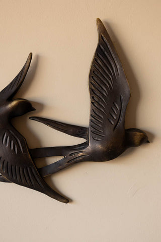 Close-up of one of the birds on the Antiqued Brass Effect Bird Wall Art, on a neutral wall.