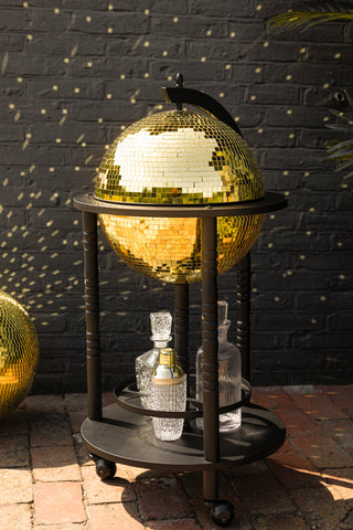 Close-up of the gold disco ball drinks trolley with a black frame outside.