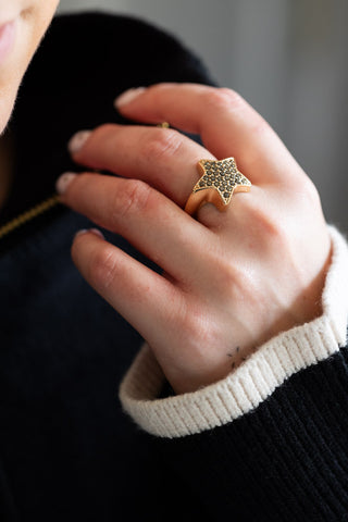 The Black & Gold Studded Star Ring worn by a model.