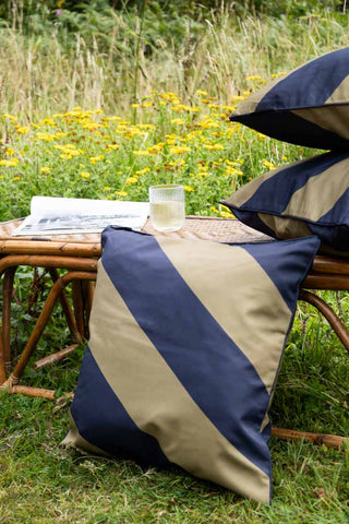 Black & Green Stripe Outdoor Cushion on bench in wild garden