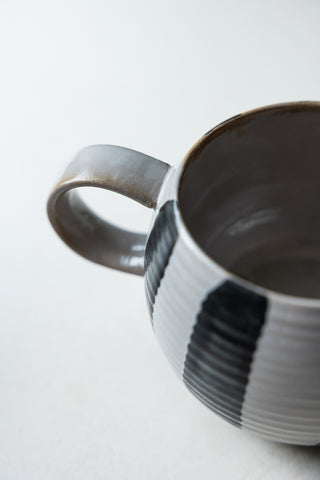 Close-up of the handle and rim of the Black & White Stripe Cuddle Mug, seen from above.