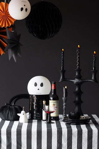 The Black & White Striped Tablecloth styled on a table with halloween decorations and black tableware.