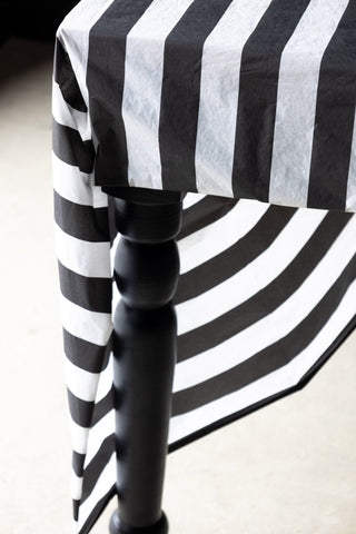 Close-up of the Black & White Striped Tablecloth on a black table.