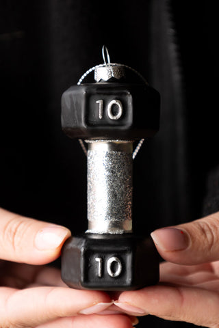 The Black Dumbbell Christmas Tree Decoration being held by a model's hands.