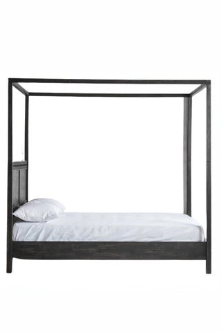 Cutout of the Boho-Inspired Boutique Four Poster Bed seen from the side, on a white background.