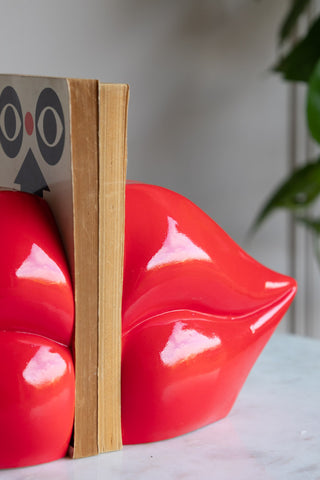 Detail of the right-hand Red Lips Bookend with two books wedged between the bookends.