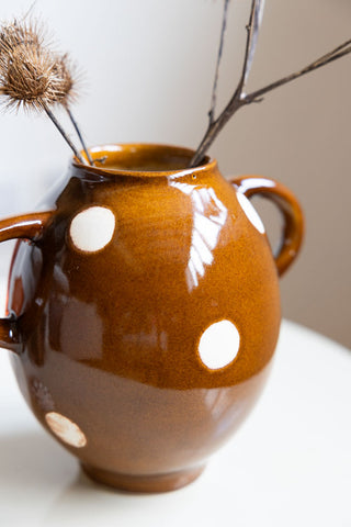 Close-up of the Brown & Ivory Dotted Display Vase styled with some flowers inside.