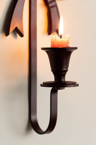 Close-up of the Burgundy Red Bow Wall-Mounted Candle Holder with a lit candle inside.