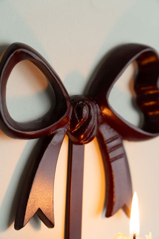 Close-up of the bow on the Burgundy Red Bow Wall-Mounted Candle Holder.