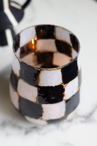 The Checkered Black & White Glass Tealight Holder seen from above, with a lit tealight inside.