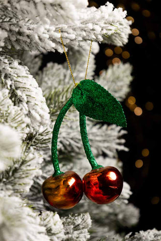 The Cherries Christmas Tree Decoration hanging from the branches of a Christmas tree.