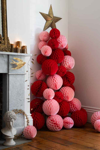 Pink and red honeycomb christmas balls in a tree formation.