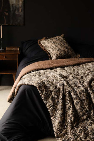 Cocoa Floral Quilt in King-Size lifestyle against dark bedding and wall 