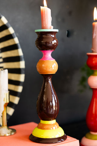 The Colourful Candlestick Holder in Chocolate & Orange styled on a book with two other candlestick holders in the background.