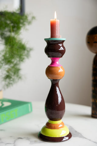 The Colourful Candlestick Holder in Chocolate & Orange displayed with a small lit pink candle inside.