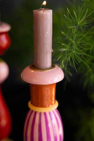 Close-up of the top of the Colourful Candlestick Holder in Pink Stripes with a lit candle inside.