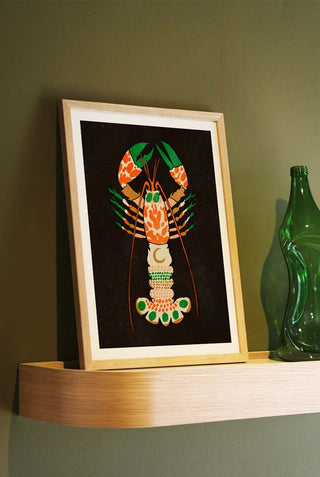 Magical lobster print framed and displayed on an oak shelf.