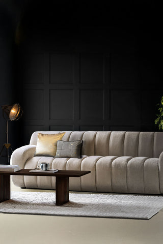 The Cream Roll Back 3-Seater Sofa styled with cushions on, with a rug, coffee table, floor lamp, plant and various accessories.