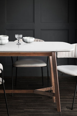 The Curved Acacia & Marble Dining Table styled with grey dining chairs, with some dining accessories on.