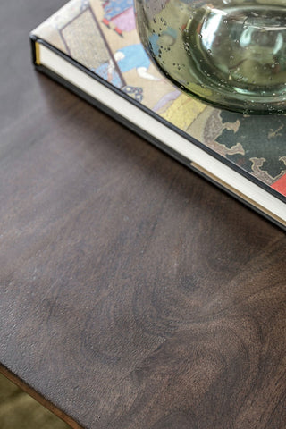 Close-up of the top of the Curved Mango Wood Coffee Table, styled with a book and a vase on.