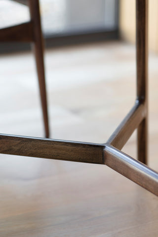 Detail image of the wooden base on the Round Acacia & Marble Dining Table.