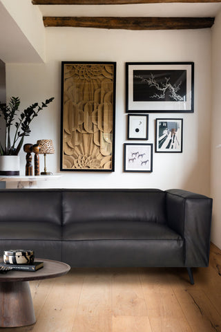 The Dark Grey 3-Seater Leather Sofa styled in a living room with a coffee table and various home accessories.