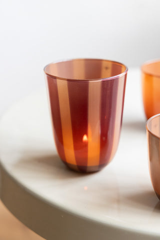 The Deep Bordeaux Striped Tealight Holder - Tall on a table with two other smaller tealight holders.