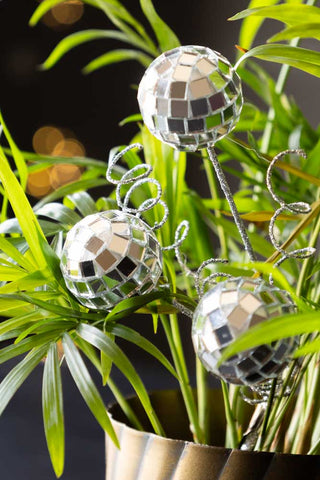 The Disco Ball Clip on Christmas Decoration styled amongst a plant in a plant pot.