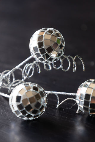 The Disco Ball Clip on Christmas Decoration styled on a dark wooden surface.