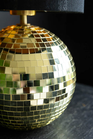 Detail shot of the base of the Disco Ball Table Lamp in Gold on a dark surface.