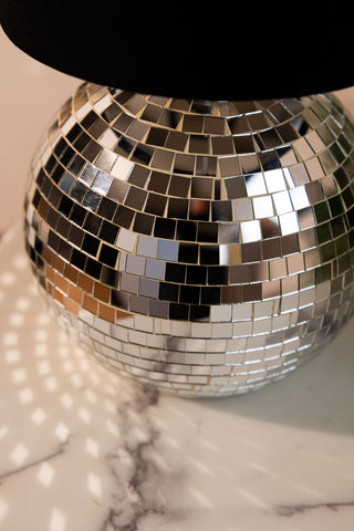 Close-up of the Disco Ball Table Lamp in Silver displayed on a white marble table.