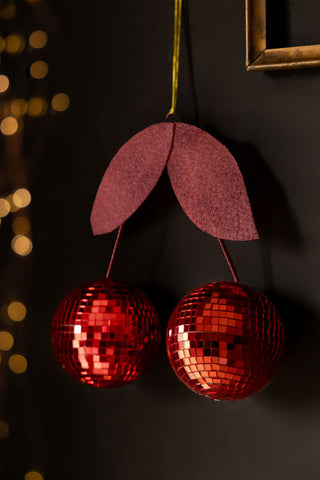 Image of the Disco Cherries Christmas Tree Decoration hung on a black wall.