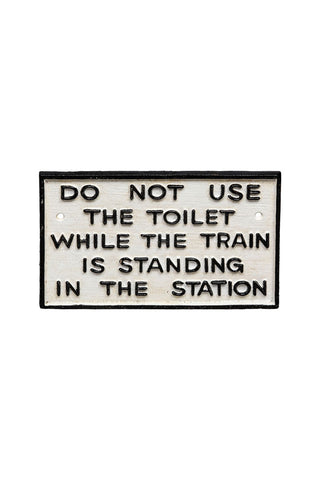 Cutout of the Do Not Use The Toilet When The Train... Hanging Sign on a white background.