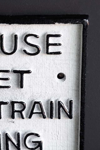 Close-up of the corner of the Do Not Use The Toilet When The Train... Hanging Sign.