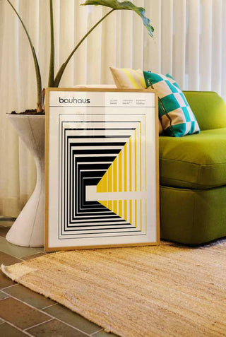 The Dynamics Art Print styled in a frame, leaning against a sofa and plant in a living room.