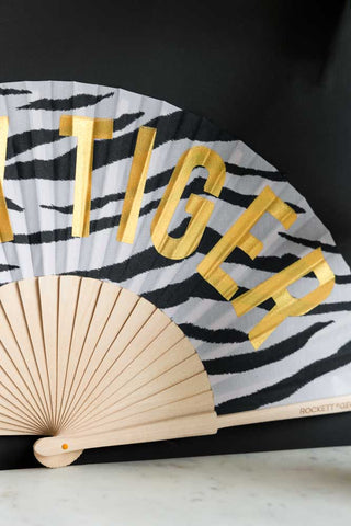 Detail shot of the Easy Tiger Print Fan leaning against a black wall.