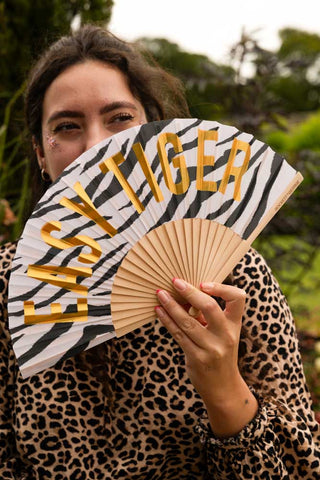 The Easy Tiger Print Fan being held by a model outdoors.